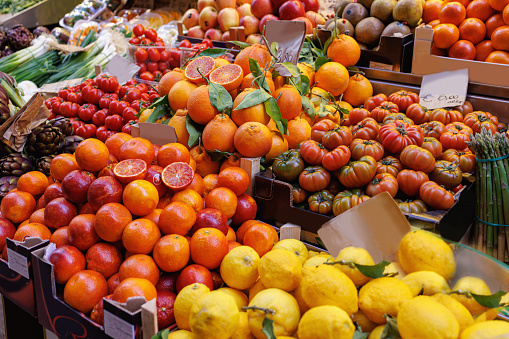 Traditional green and food market stall in Bologna, Italy; citrus fruit and fresh vegetables