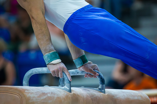 Symbol image of apparatus gymnastics: Close-up of an apparatus gymnast on the pommel horse