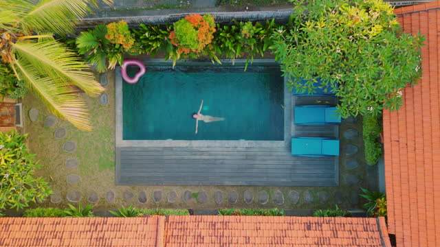 Aerial view of woman resting at swimming pool