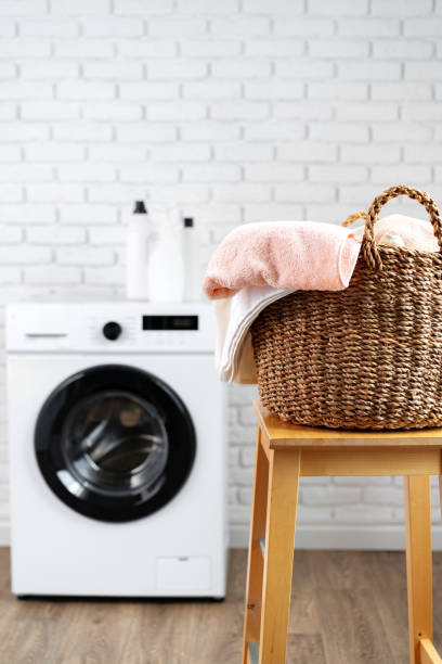 istock Laundry room with washing machine and basket with laundry 1690140261