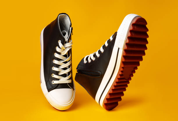 istock New black and white canvas sneakers on yellow background 1690161890