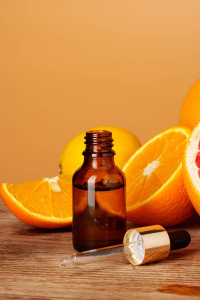 istock Glass bottle with essential citrus oil on orange background 1690173151
