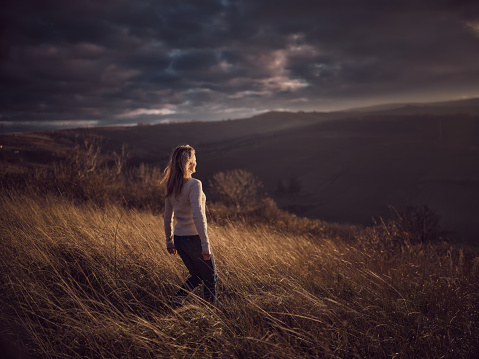 Rear view of carefree woman walking during autumn day on a hill. Photographed in medium format. Copy space.