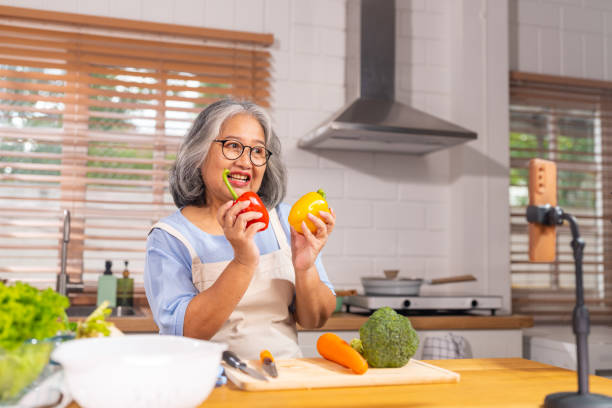 istock Grandmother live streaming cooking meal in the kitchen. 1690208912