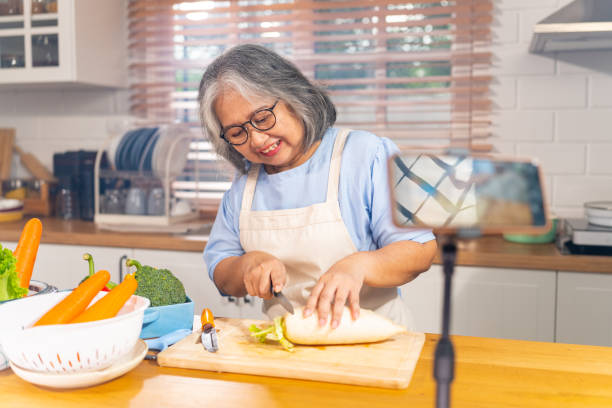 istock Grandmother live streaming cooking meal in the kitchen. 1690209491
