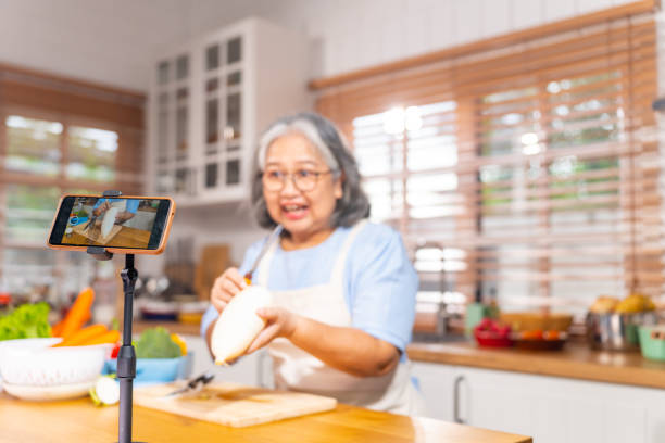 istock Grandmother live streaming cooking meal in the kitchen. 1690209502