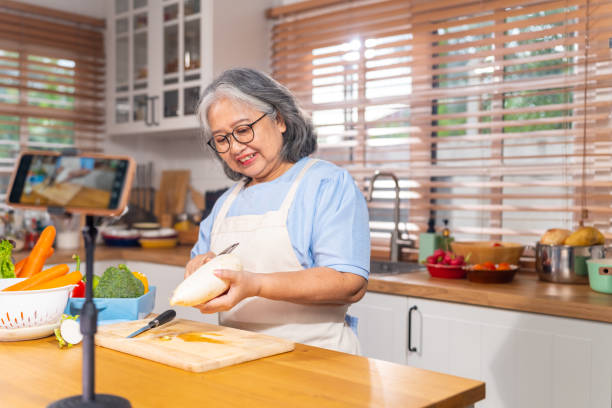 istock Grandmother live streaming cooking meal in the kitchen. 1690209503