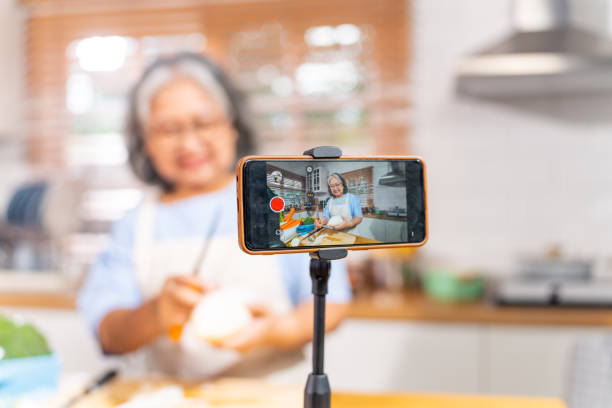 istock Grandmother live streaming cooking meal in the kitchen. 1690210022