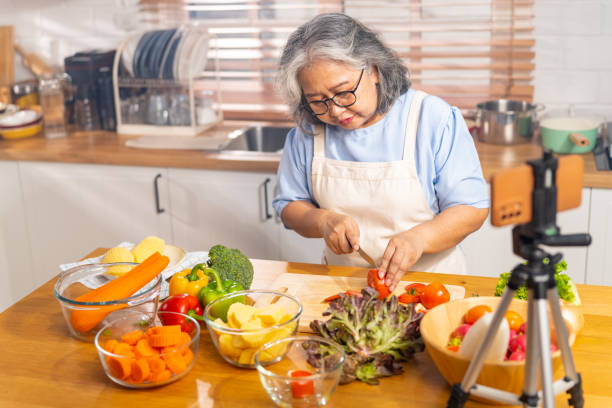 istock Grandmother live streaming cooking meal in the kitchen. 1690210599