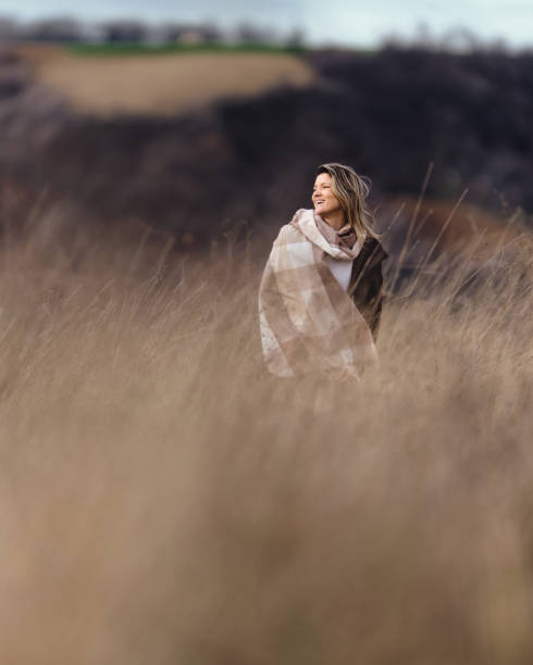 istock Happy woman spending an autumn day in tall grass. 1690214411
