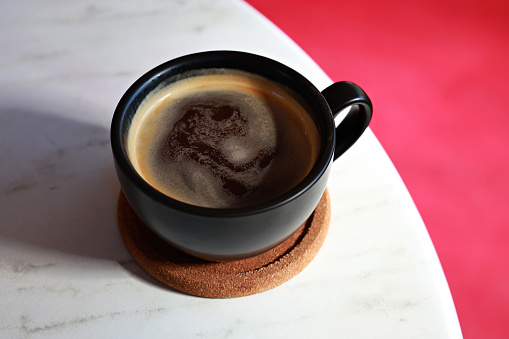A close-up of black coffee on a marble table