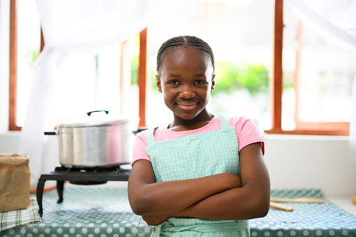 Young girl standing in kitchen ready to cook
