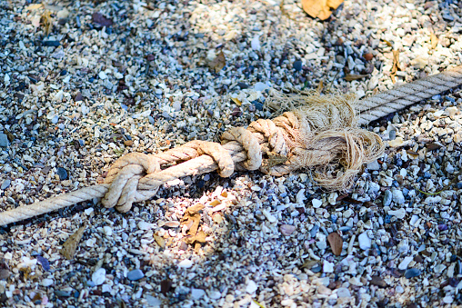 blue rope tied to a boat on the beach, close-up
