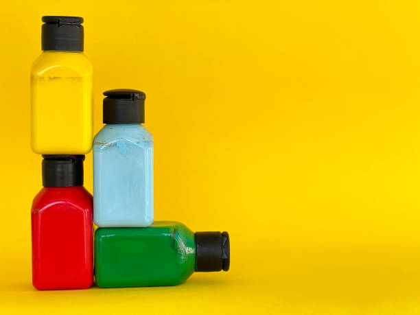 istock Bottles with bright multi-colored acrylic paint on a yellow background 1690265020