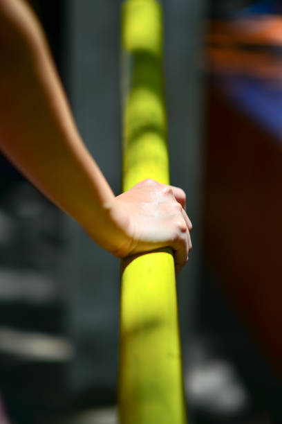 istock Hanging from a rope, one woman's hand gripped a long pipe tightly. 1690269626