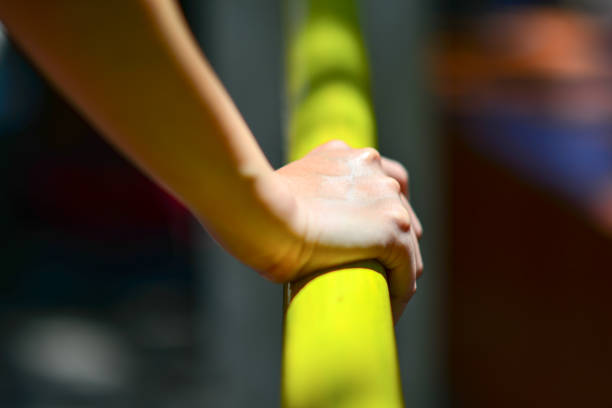 istock Hanging from a rope, one woman's hand gripped a long pipe tightly. 1690269628