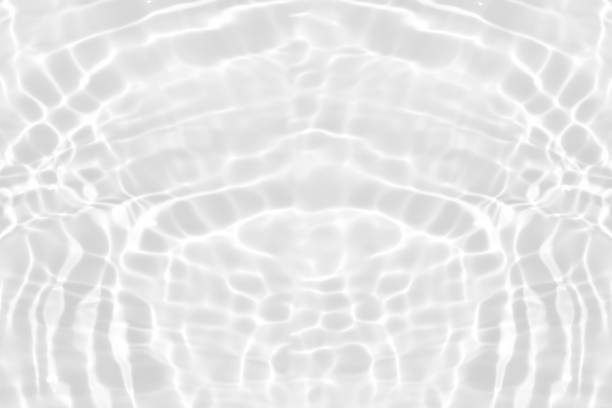 Defocus blurred transparent white colored clear calm water surface texture with splashes reflection. Trendy abstract nature background. Water waves in sunlight with copy space. Blue watercolor shine.