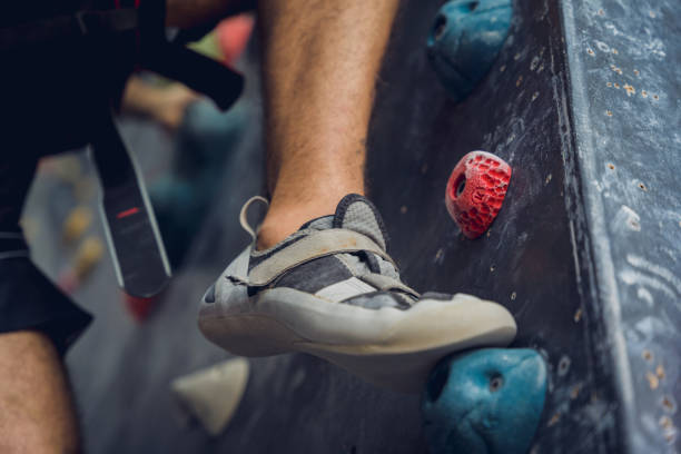 istock A strong male climber climbs an artificial wall with colorful grips and ropes. 1690285405