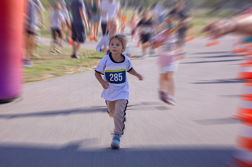 Young preschool children, running on track in a marathon competition in the park