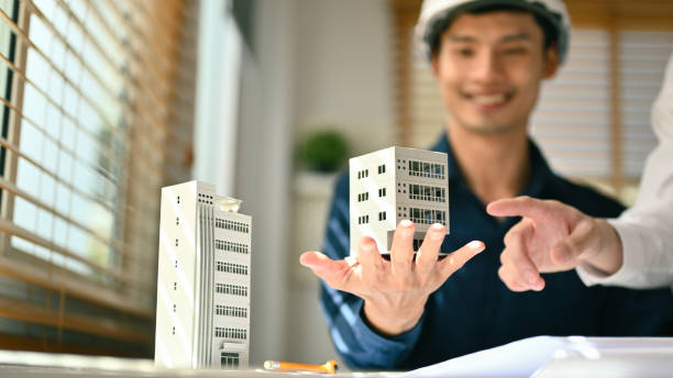 istock Architects team working with architectural model model of residential at meeting. Construction, property and real estate 1690286477
