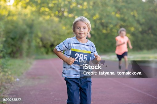 Young preschool children, running on track in a marathon competition