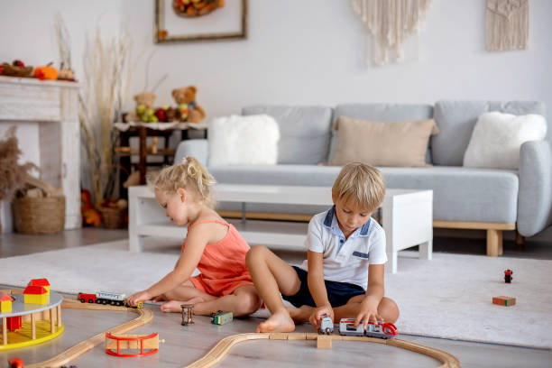 istock Two sweet children, siblings, playing with trains at home 1690292500
