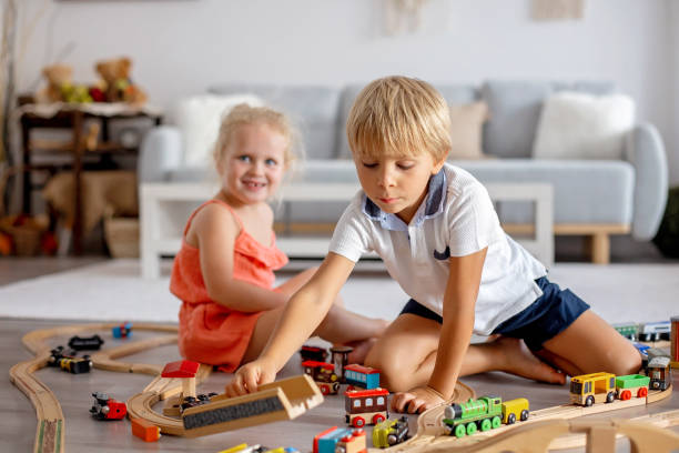 istock Two sweet children, siblings, playing with trains at home 1690293029