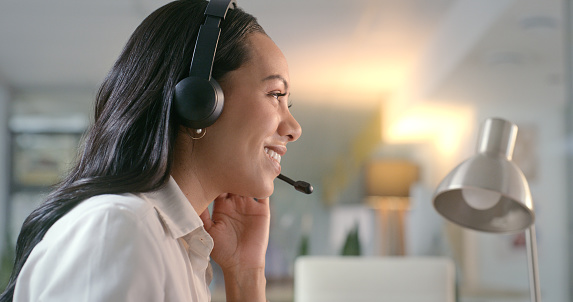 Face, woman and call center headset office at night for customer service, crm and network. Headshot of friendly consultant or contact us agent for telemarketing, sales or advice for technical support