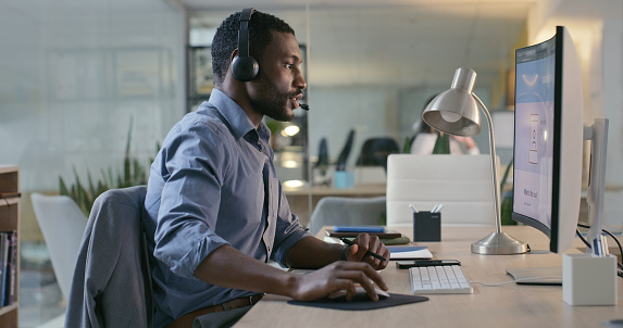 Business, call center or black man with telemarketing, computer or internet with connection in workplace. African person, employee or worker with pc, headphones or customer service with tech support