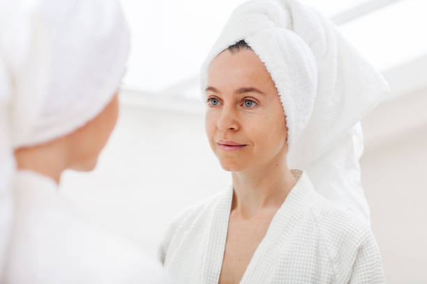 istock Beautiful middle-aged woman look in mirror in bathroom 1690302532