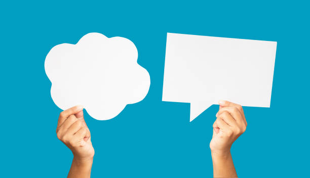 istock Close-up of hands holding a white speech bubble against a blue background 1690307606