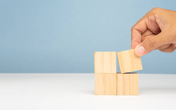 istock Four wooden cubes on a marble table with a light blue background 1690309177