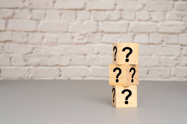 istock Wooden cubes stacked with question mark symbols on a gray floor 1690311369