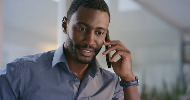 istock Phone call, communication and professional black man in the office in conversation for networking. Success, technology and young African designer on mobile discussion with cellphone in workplace. 1690322610
