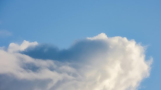 A picture of a beautiful, clear blue sky with white, soft, cotton-like clouds scattered throughout