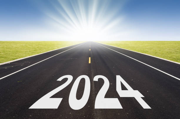 istock 2024 road perspective with rising sun, hope new year card 1690371471