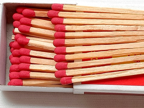 Antique matchsticks, wooden stem, red head, placed on a box on a white background. Antique matches from the 90's.
