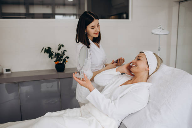 istock Cosmetologist doing face treatment and applying face mask 1690380279
