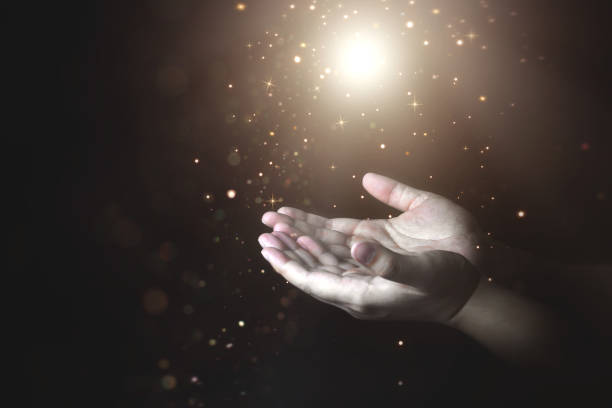 istock Praying hands of men with light shining from above. 1690381380