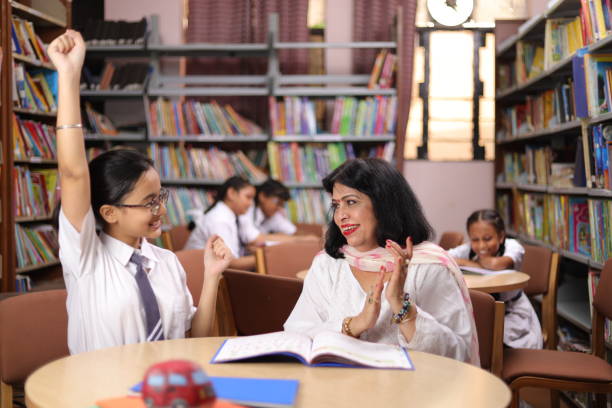 istock Confident school teacher teaching, educating  girl child student in library, excitement, hands up, yay, clapping. 1690387664