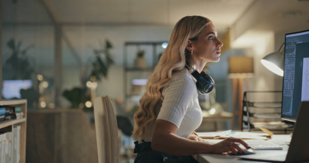 istock Serious, business woman and designer on computer in office at table working on deadline. Creative, pc and professional planning at desk, reading email and editing software project in startup at night 1690409810