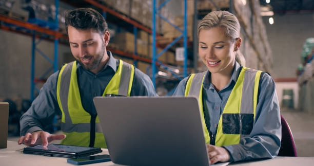 istock Factory, laptop and management working on logistics online for a team together in a warehouse with industrial inventory. Distribution, tablet and teamwork by commerce employees planning supply chain 1690430596