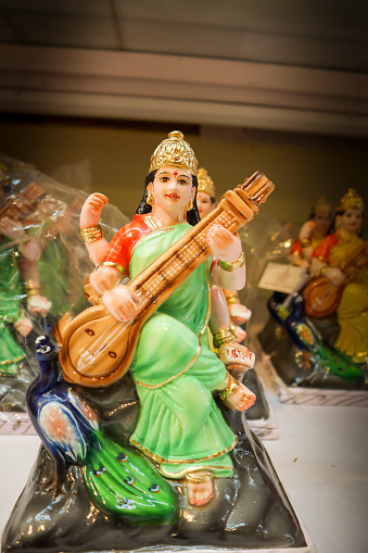 Mysuru, Karnataka, India-August 30 2023; A Vibrant color Figurine portraying Goddess Saraswathi playing Veena instrument during the Diwali and Dasara Doll festival in Mysore palace in Karnataka, India.