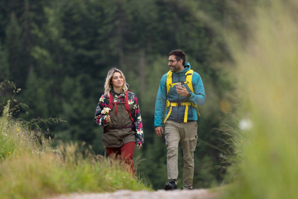 istock Young smiling couple of hikers walking through wilderness. 1690462236