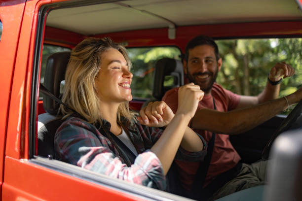 istock Carefree couple dancing during a road trip in a car. 1690470802