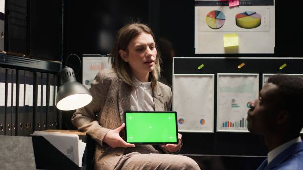 istock Detective holds tablet with greenscreen 1690474173