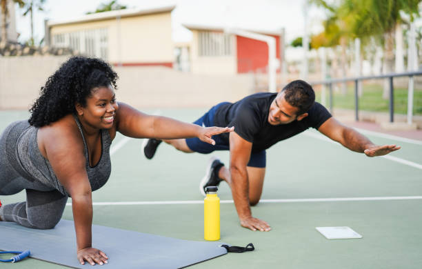 istock African curvy woman and personal trainer doing functional workout training session outdoor - Sport and healthy lifestyle concept - Main focus on girl face 1690474184
