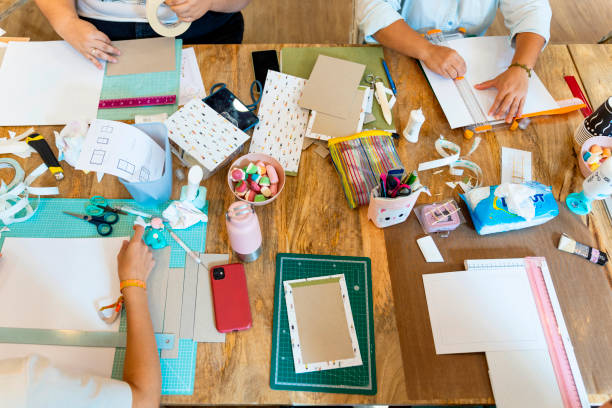 istock Scrapbook workshop. Women enjoying the workshop with sweets and tools 1690492933