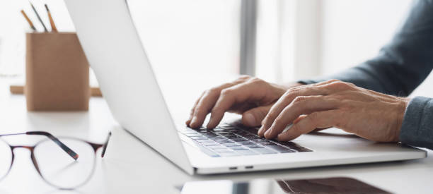 istock Man working in office. Businessman using laptop at home, web banner 1690509434