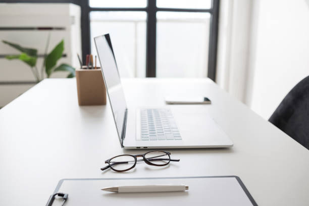 istock Place of work in office, laptop computer, glasses at office desk 1690509643